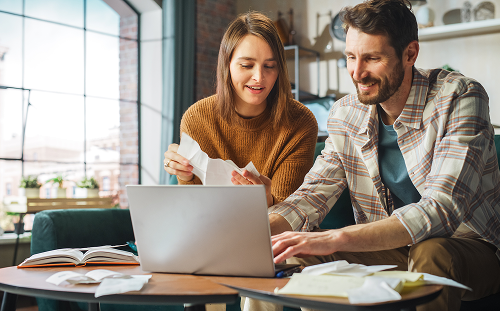 Homeowners reviewing utility bills online to qualify for income-based appliance recycling and energy efficiency programs